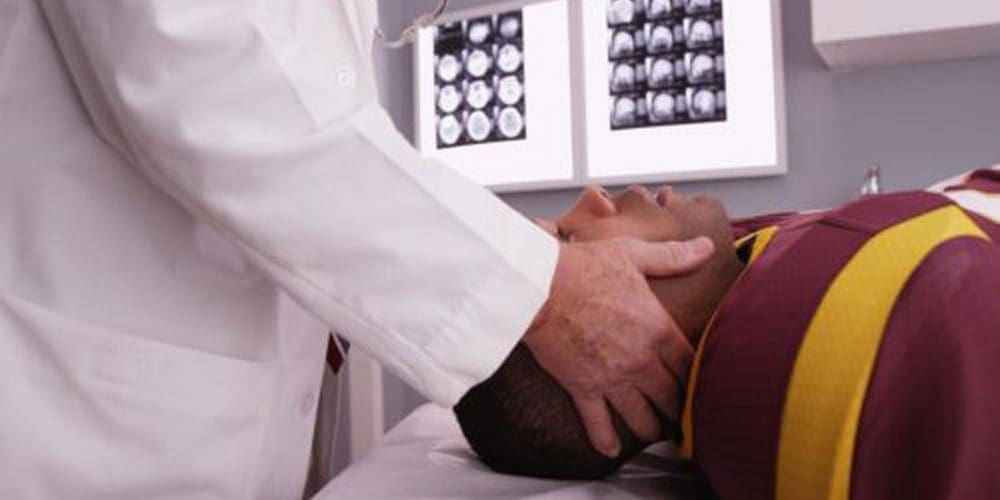 A chiropractor is treating a man's auto accident injuries after taking x-rays.