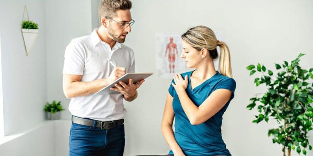 A chiropractor is consulting with a new patient and answering her questions.