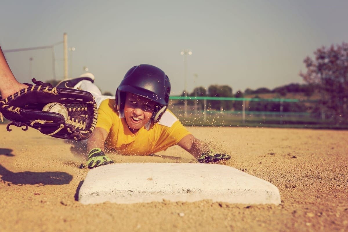 A baseball player slides to third base.