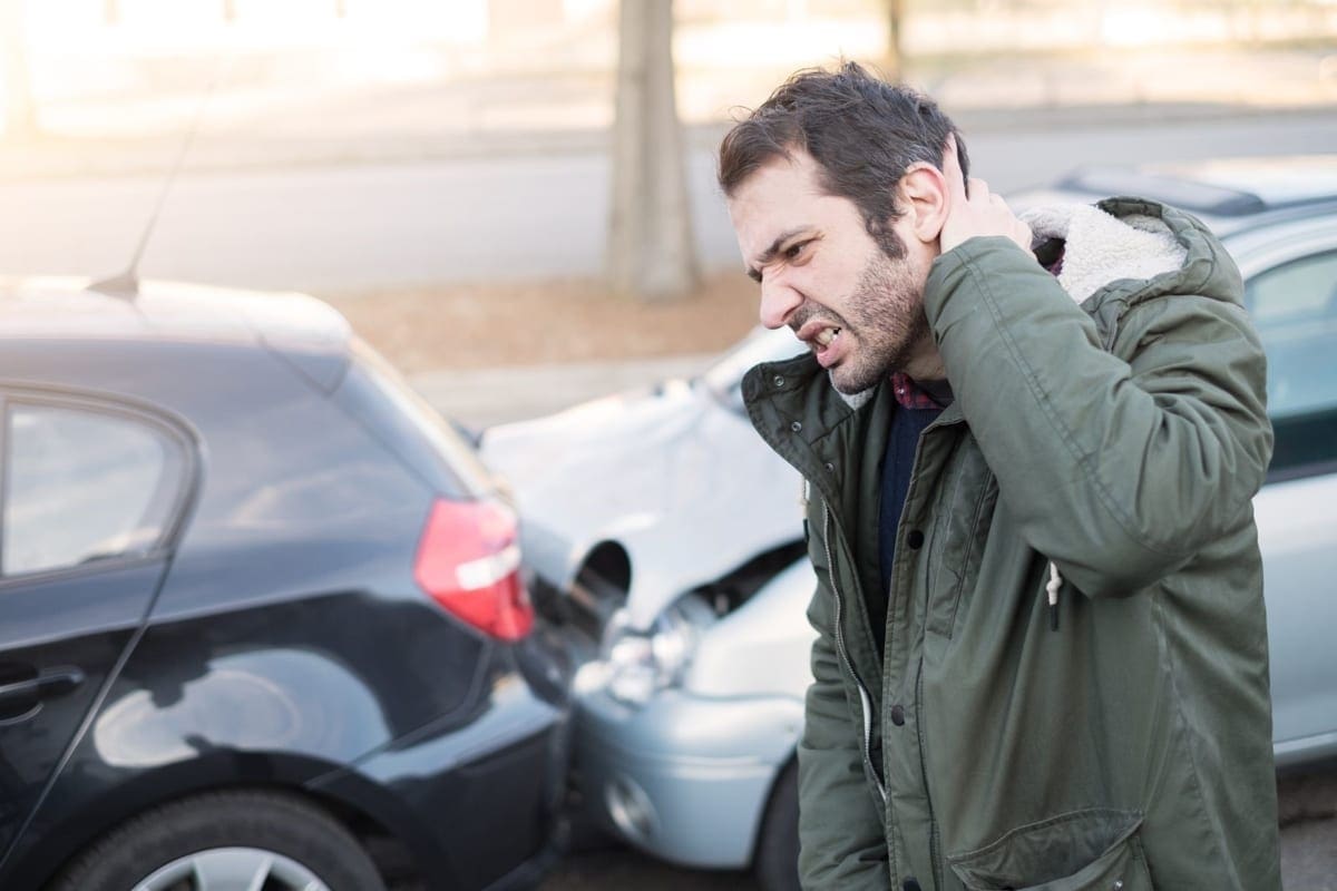 A man is suffering from whiplash pain after an accident.