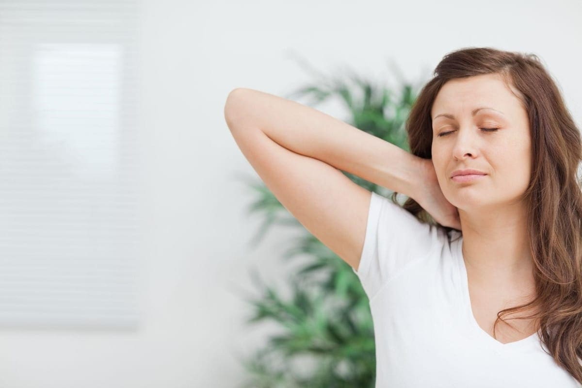 A woman suffers from neck pain.