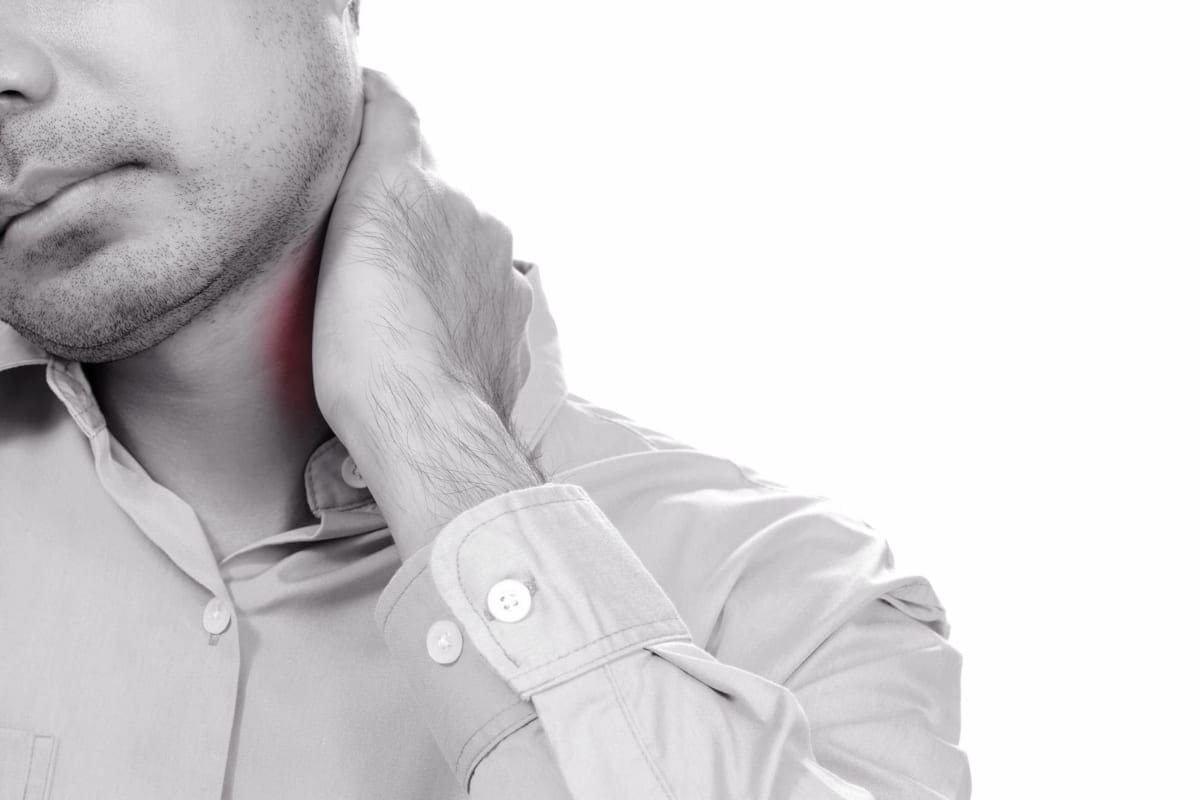 A back tilts his head and has his hand on his neck because of neck pain.