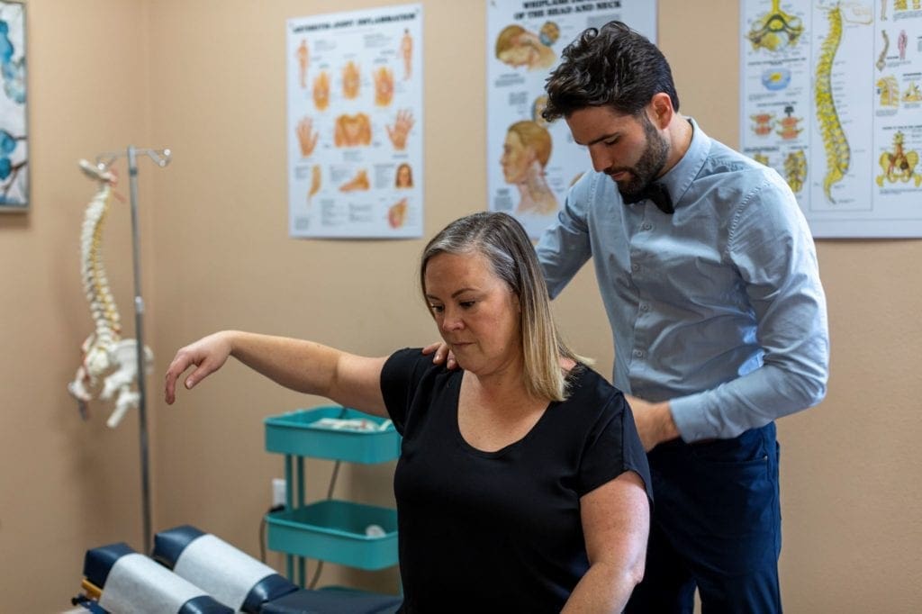 Tigard Chiropractor treating a woman's shoulder pain and whiplash.