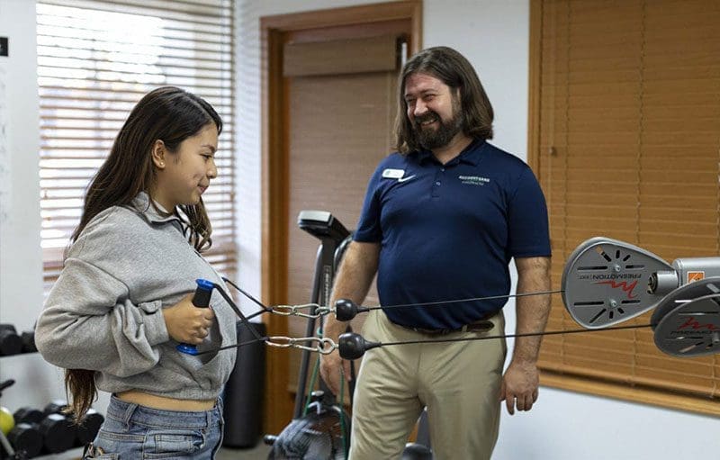 A woman is doing physical therapy exercises for rehabilitation at Accident Care Chiropractic in Portland.