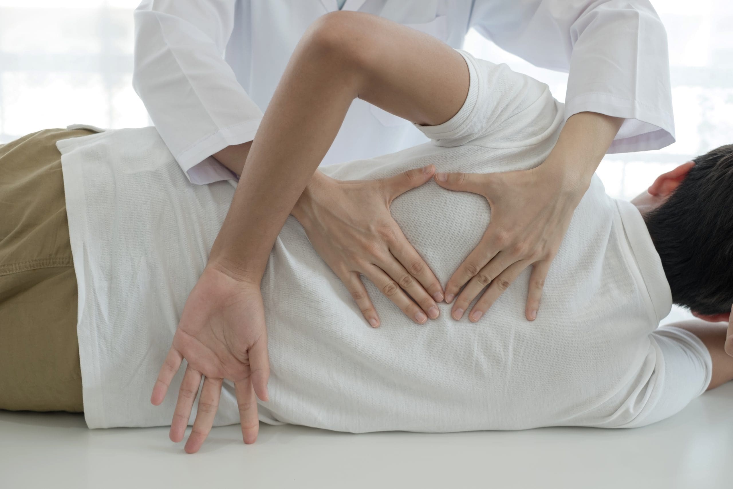 A chiropractor physiotherapists provide physical assistance to male patients with back injuries back massages for relaxation and muscle recovery in the rehabilitation center.