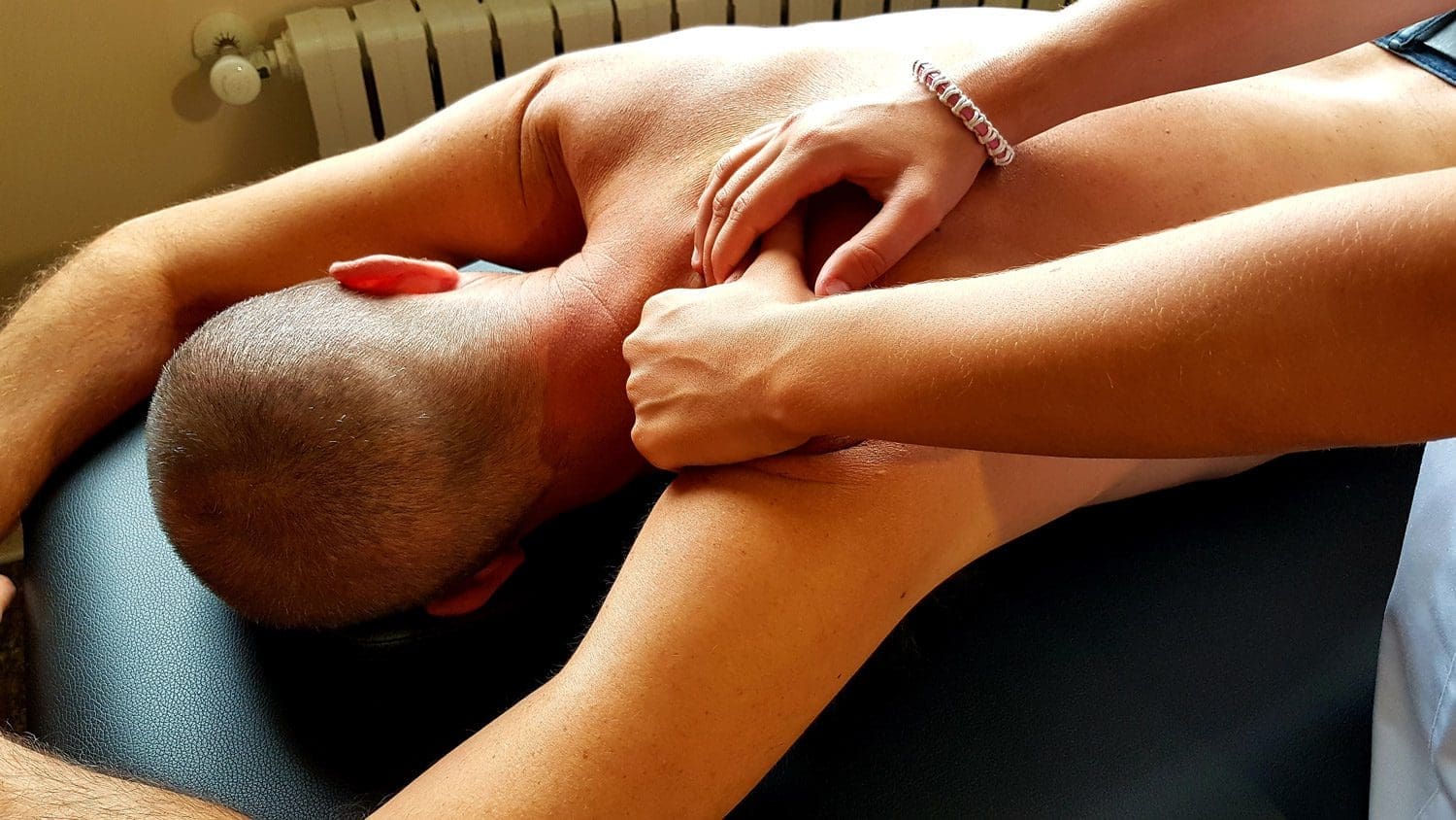A man is getting a massage at the chiropractic clinic in Beaverton, Oregon.