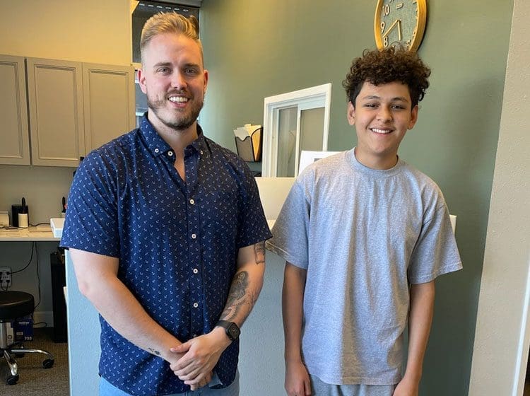 Dr. Travis Fontaine, D.C. with young patient smiling who recovered from auto injury.