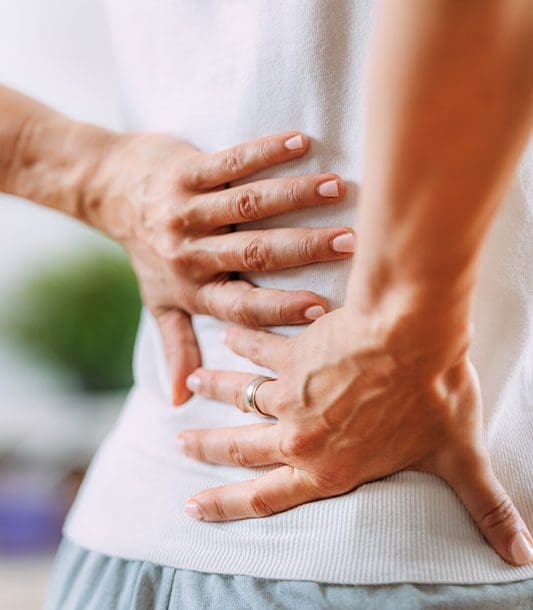 A close up of a persons lower back experiencing back pain caused by sciatica.