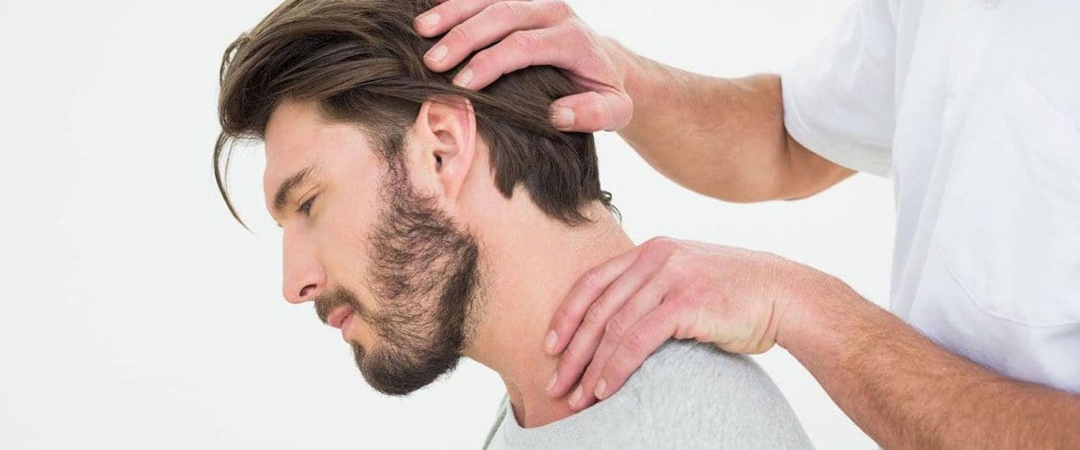 A man is receiving a chiropractic neck adjustment after a car accident.