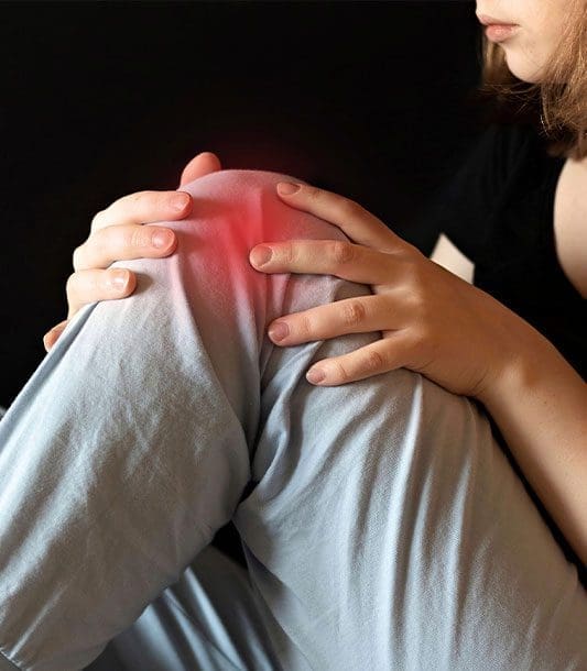 A woman suffering from knee pain.
