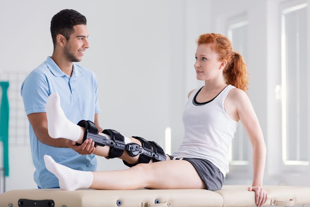 A chiropractor is administering treatment for a ligament sprain in her leg.