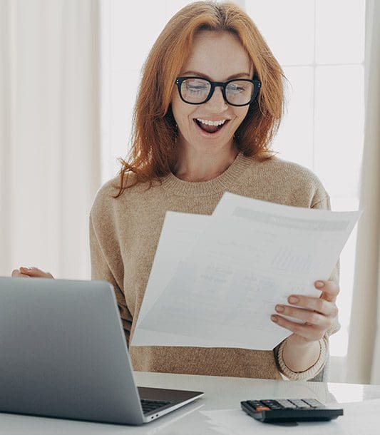 A woman is reading her car accident settlement and is very happy.