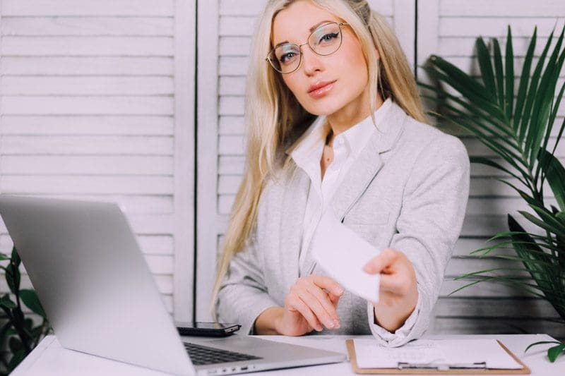 A chiropractors is sitting at her desk helping a patient settle car insurance claim, and getting chiropractic care covered by insurance.