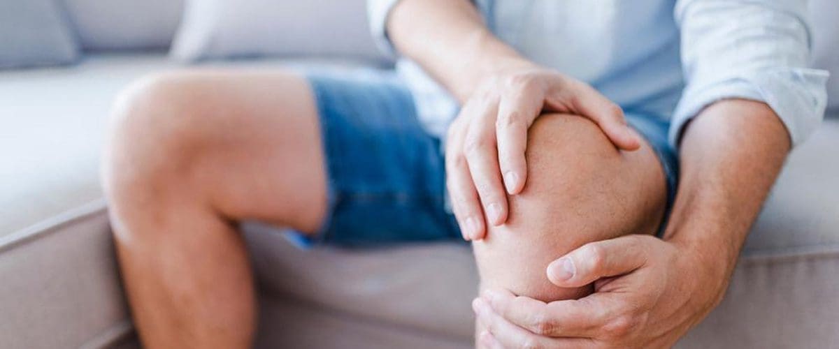 A man cannot stand up because of knee pain.