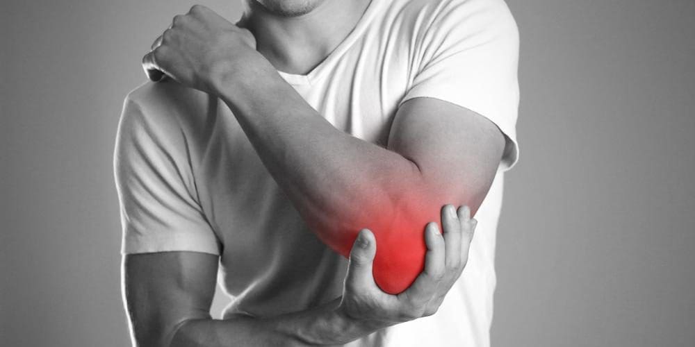 A man his holding his elbow because of intense elbow pain.