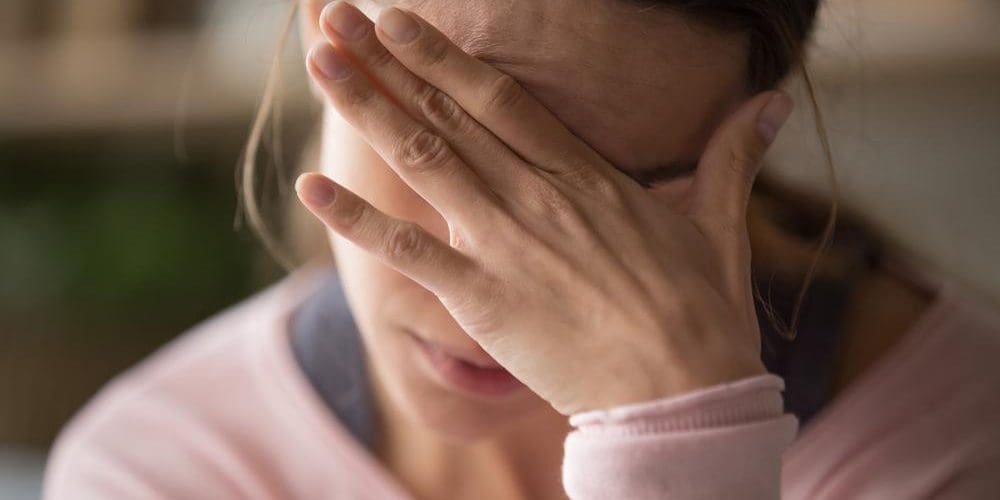 A woman is suffering from a bad headache.