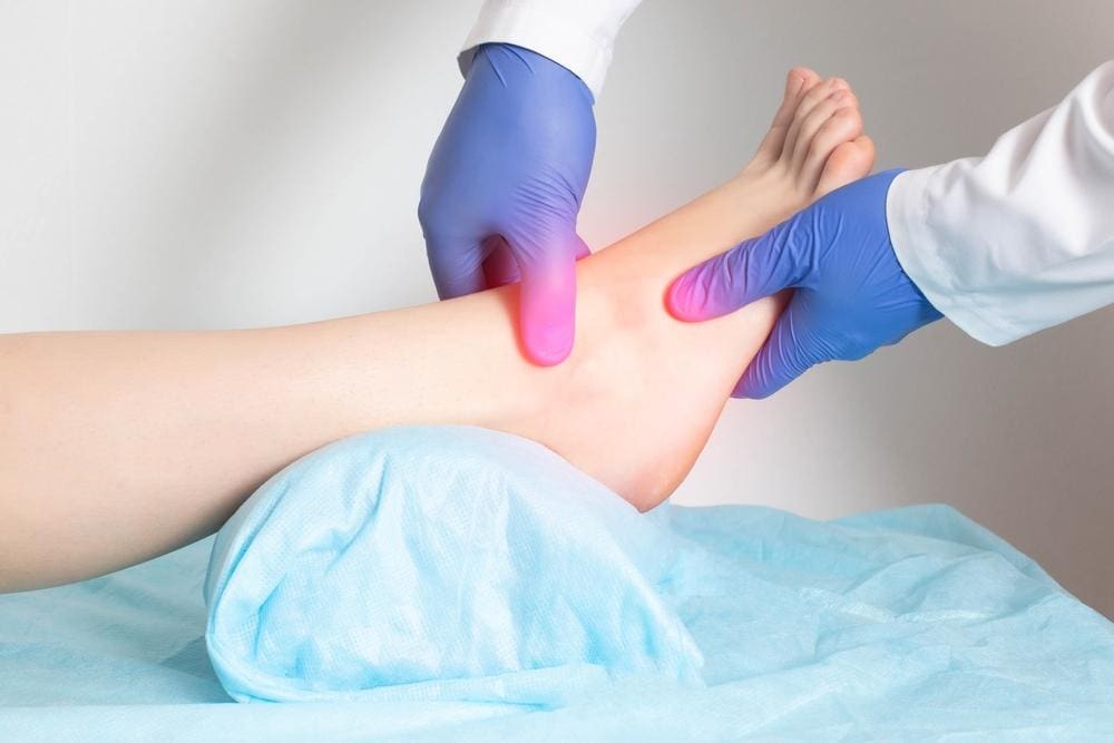A doctor examining an ankle sprain.
