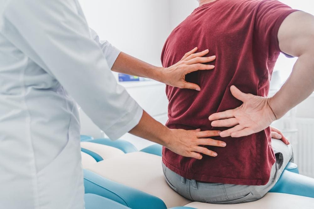 A chiropractor is treating a man for herniated disc pain.