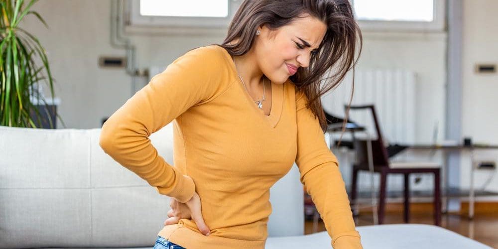 A woman is suffering from nerve damage pain in her lower back.