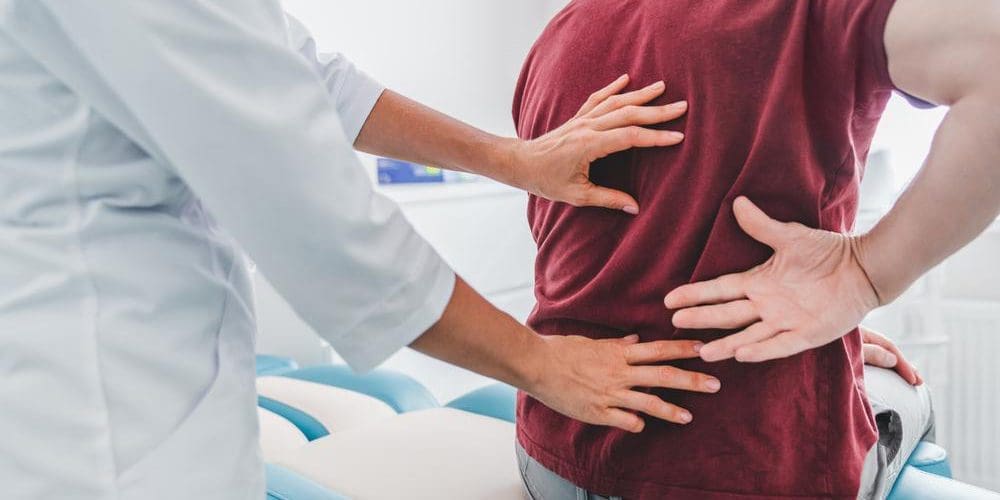 A man is seeing a chiropractor for a pinched nerve.
