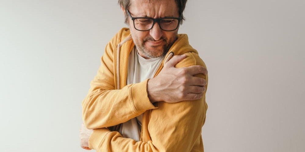 A man in in pain from shoulder bursitis.
