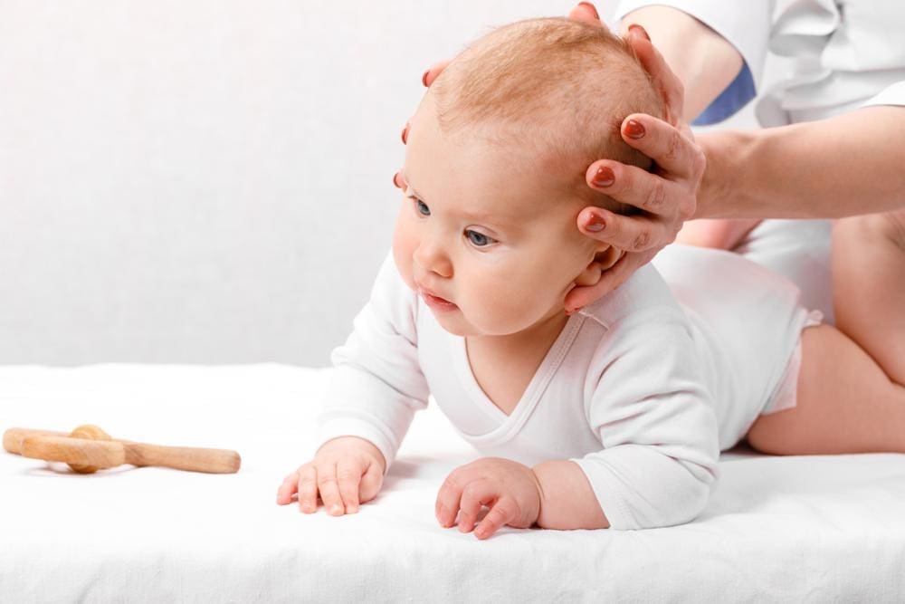A baby is getting a chiropractic adjustment.
. 