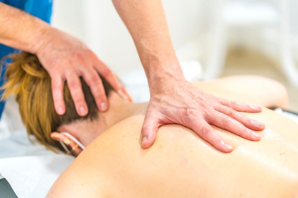 A chiropractor is treating a woman who has symptoms of long Covid. 
