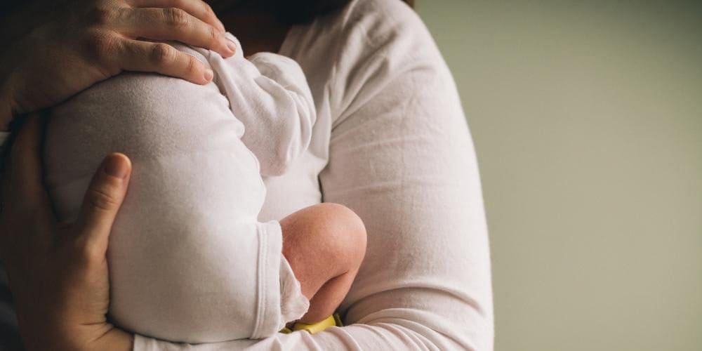 A mother is holding her newborn after childbirth.