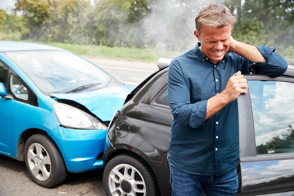 A man has a bad headache after a rear end collision. 
