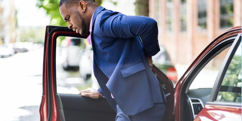 A man's back hurts after a car accident, because of disc herniation.