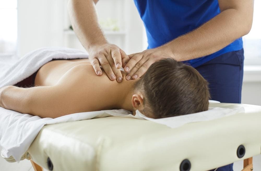 A young man is getting a chiropractic adjustment to treat trigeminal neuralgia pain. 
