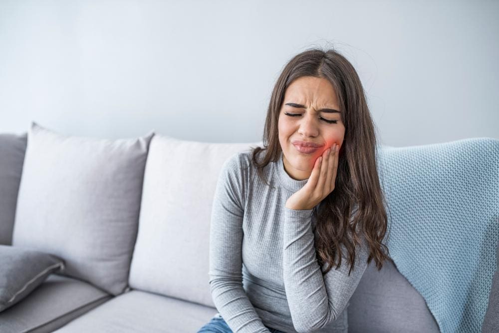 A woman is experiencing trigeminal neuralgia pain in her jaw.
