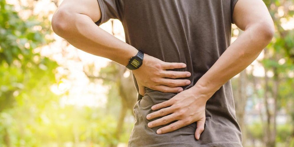 A man is holding his lower back because he was recently injured.
