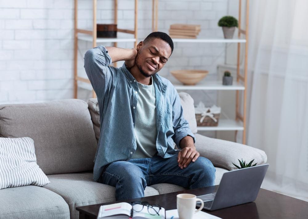 A young man is in pain because of a herniated disc in his neck.