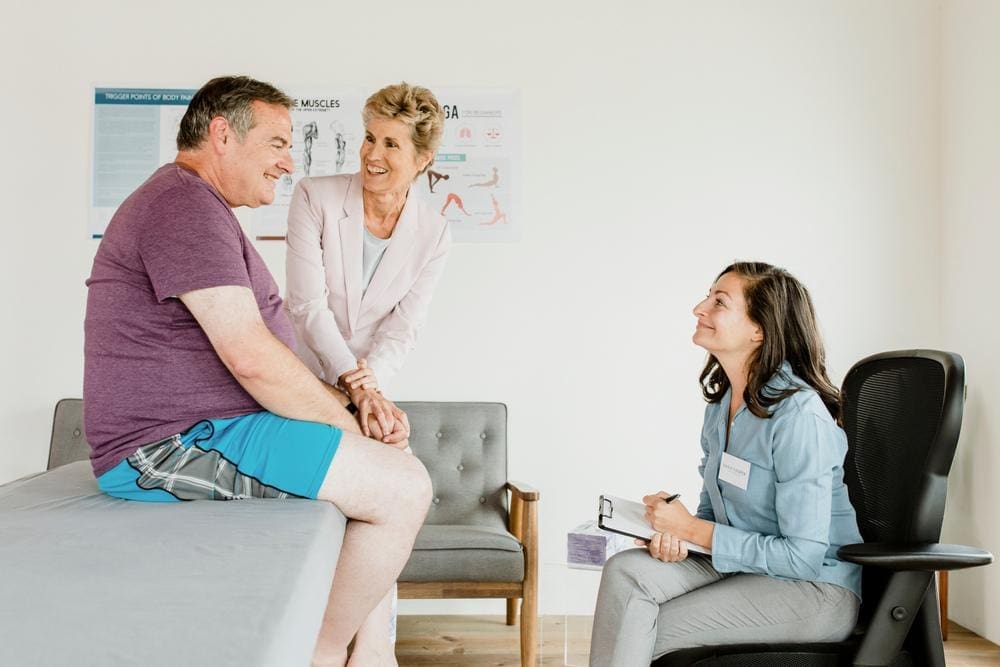 An overweight man is consulting with his chiropractor for a tailored plan to help manage obesity. 