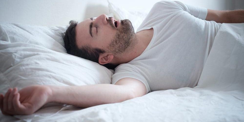 A man is in bed sleeping.