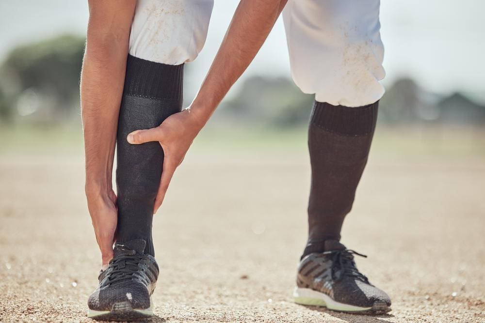 A baseball player has sprained his ankle on the field. 