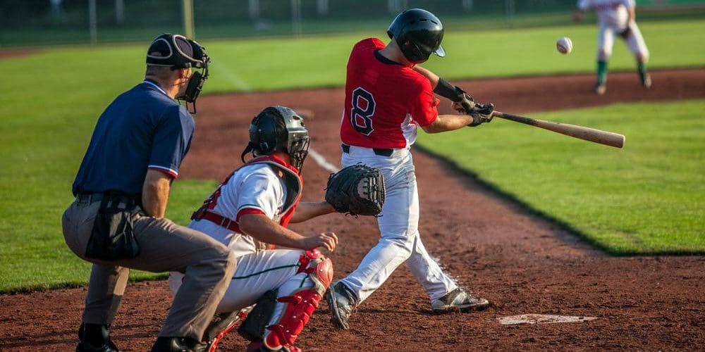 A batter swings and hits the ball during a baseball game.