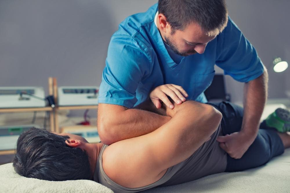 A chiropractor is adjusting a baseball player to relieve inflammation and improve flexibility. 