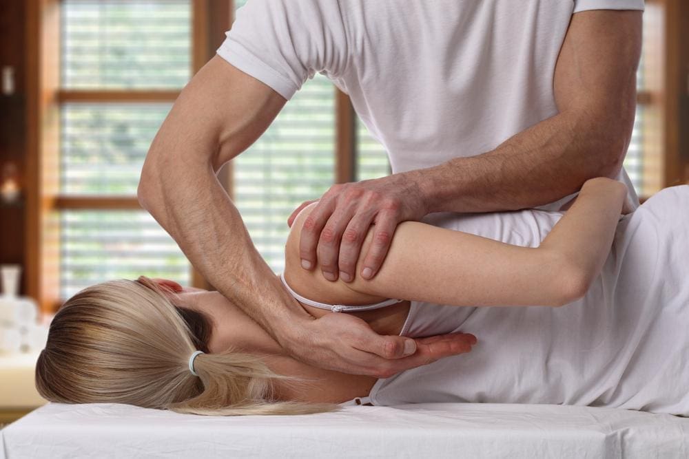 A woman is getting a chiropractic adjustment. 