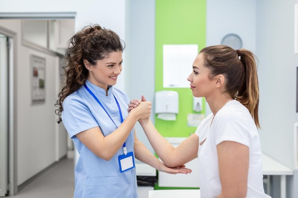 A chiropractor is examining a woman's arm before treating her neuropathy pain.