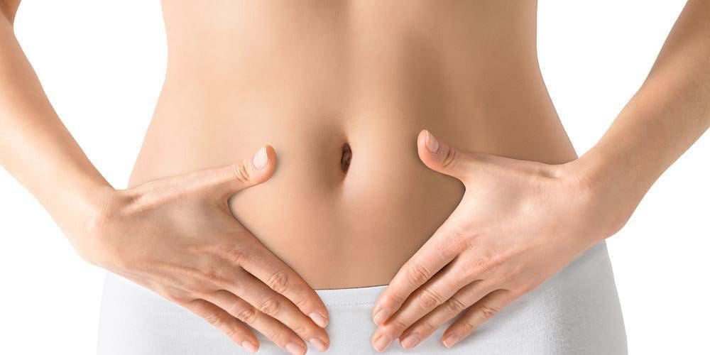 A woman holding her hands on her belly.