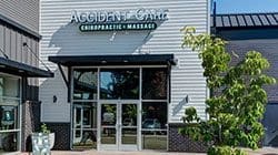 Outside of Forest Grove Chiropractor Clinic showing entrance with flowers and logo sign.