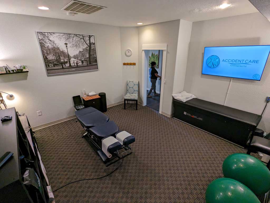 Angled view of Gresham Clinic treatment room with chiropractor table.