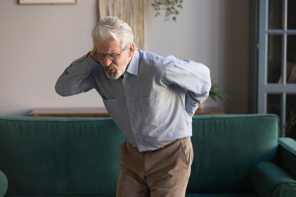 A man is experiencing neck and back pain after a slip and fall injury. 
