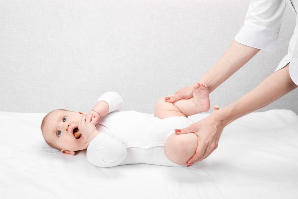 Chiropractor treating a six-month-old for hip dysplasia.
