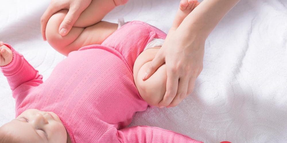 Woman doing hip exercises with infant.
