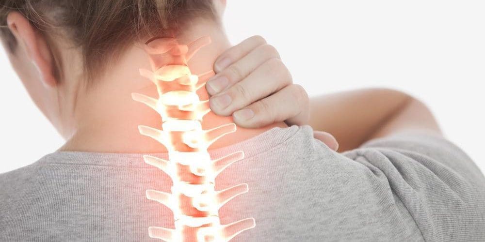 Woman rubbing her neck with her spine digitally highlighted.