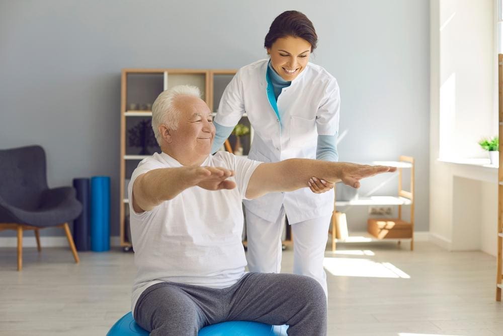 Chiropractor working with a happy elderly man that has dementia.