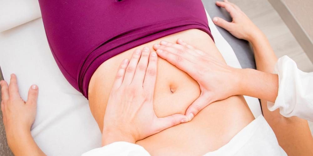 Chiropractor doing an abdominal massage on a patient with Pelvic Floor Dysfunction.